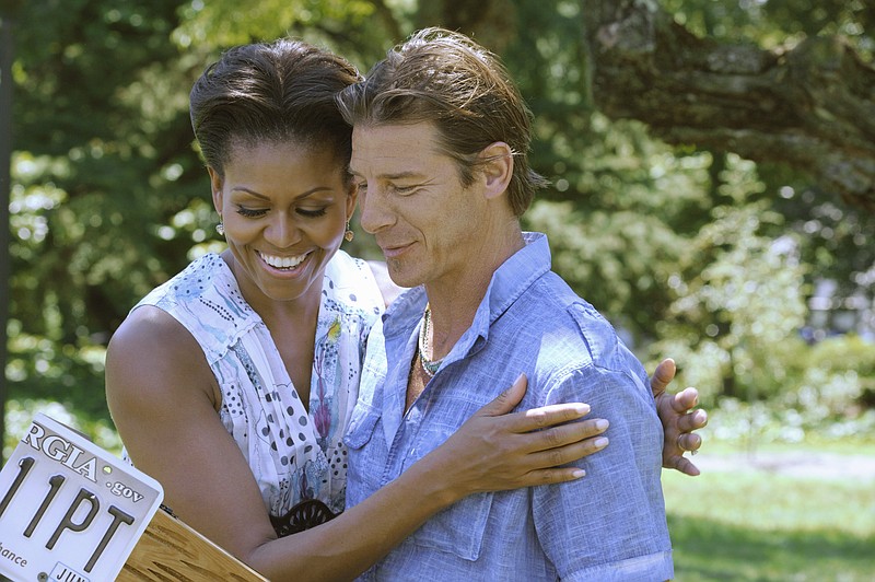 In this image released by ABC, first lady Michelle Obama, left, embraces host Ty Pennington during a taping of a two-part premiere of the home makeover series, "Extreme Makeover: Home Edition," in Washington. As part of her Joining Forces initiative, Michelle Obama participated in the episode featuring the Marshalls, a military family based in Fayetteville, N.C. 