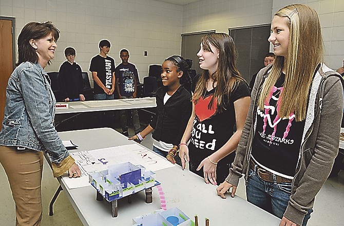 Principal Sherri Thomas, left, asks where the principal's office is as Lewis & Clark seventh-graders Amanda Davidson, right, Taylor Meyer, second from right and Akeyah Alston describe their mock-up of the planned academy system for the school district.