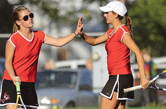 Jefferson City doubles partners Blaire Dawdy (left) and Shelby Horn congratulate each other after winning a set during Tuesday's dual with Marshall at Washington Park.