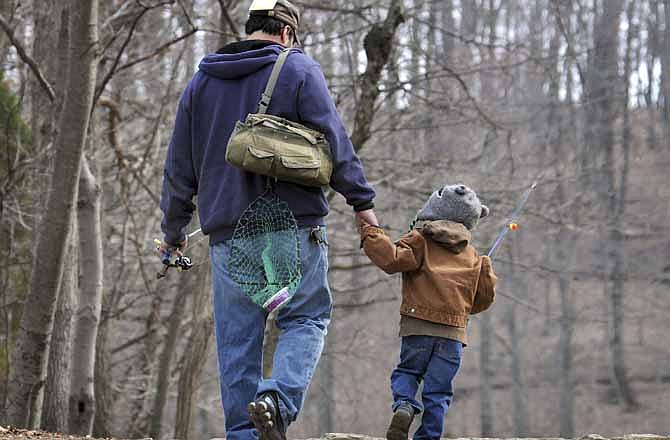 In this April 3, 2011 file photo, a father and son head for their fishing hole at Muddy Run Recreation Park in southern Lancaster County, Pa. New research suggests that dads are less likely to die of heart-related problems than childless men are. (AP Photo/Intelligencer Journal, Marty Heisey)