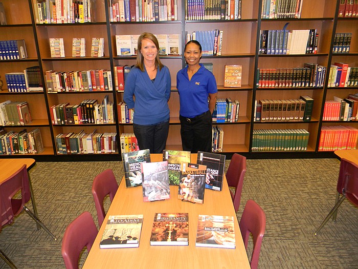 California High School Library Media Specialist Janet Henley, left, and California Sonic General Manager Pam White, right, with eight Britannica reference books purchased through the "Limeades for Learning" contest.