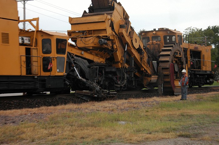 The rotary scoop at the right in the photo above removes the rocks from the shoulder of the railroad track, then cleans and sorts it, with the rocks replaced in a smoothed shoulder in the center. The machine is operated by a person in the cab at the left.