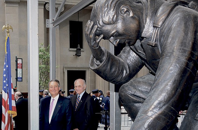Emigrant Savings Bank president Howard Milstein, left, and New York Fire Department Commissioner Nicholas Scoppetta participate in the Sept. 22 dedication of The Kneeling Fireman statue in front of Emigrant Savings Bank in midtown Manhattan. 