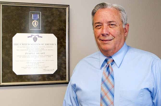 Roger Stottlemyre stands near the framed Purple Heart awarded him as a Marine.