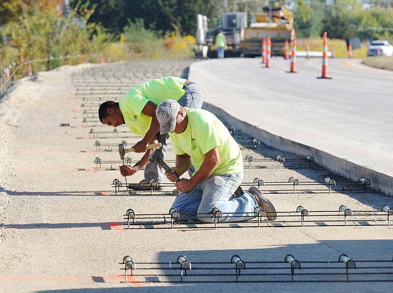 Workers from Lehman Construction Company in California fasten concrete support structures in place before cement is poured. Progress continues on the new entrance and exit lanes on U.S. 54, from Honey Creek to south of Brazito. 