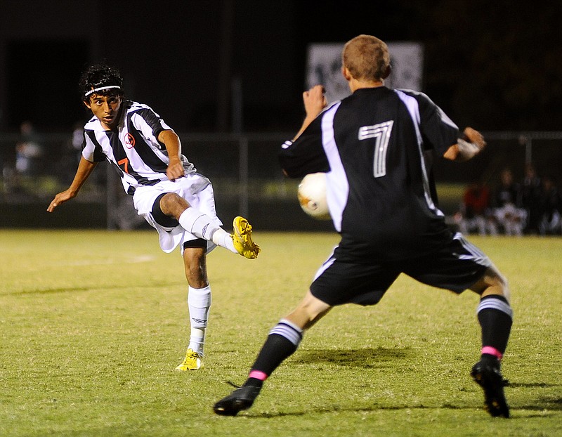 Jefferson City's Sergio Celada (left) tries to fire a pass beyond Smith-Cotton's Jacob Lamb during Tuesday night's game at the 179 Soccer Park.