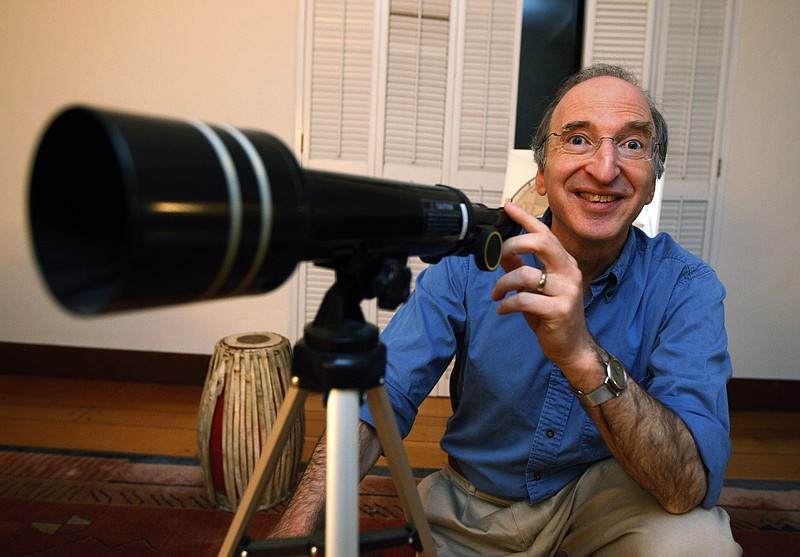 Nobel Prizes winner for physics, Saul Perlmutter, smiles Tuesday as he poses with his daughter's telescope at his home in Berkeley, Calif. after hearing he had won. The Royal Swedish Academy of Sciences said American Perlmutter would share the $1.5 million award with U.S.-Australian Brian Schmidt and U.S. scientist Adam Riess.