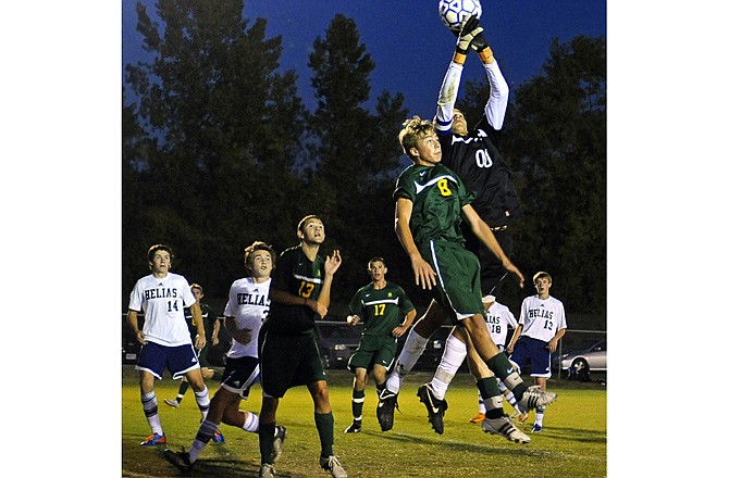 Helias goalie Joe Keeven (00) stops a Rock Bridge corner kick as Bruin's forward Eli Sherman tries to knock the ball loose during Tuesday's game at the 179 Soccer Park.