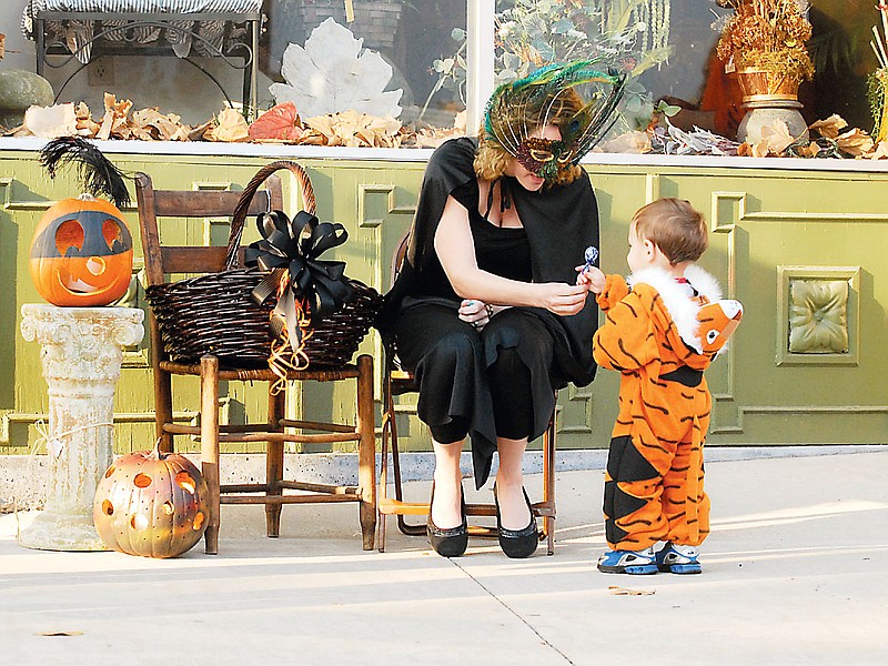 Largo Haight hands Matthew Quick, then 1, a sucker during Downtown Trick-or-Treating in 2007. This year's event will take place from 3:30-5 p.m. on Oct. 31.