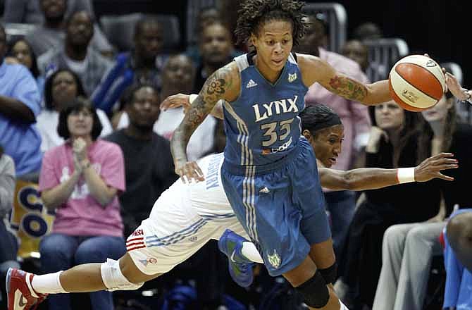 Minnesota Lynx guard Seimone Augustus (33) dribbles past the reach of Atlanta Dream guard Angel McCoughtry during the second quarter of Game 3 of the WNBA basketball finals on Friday, Oct. 7, 2011, in Atlanta.