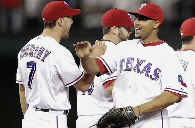 Texas Rangers' David Murphy, left, and Nelson Cruz react after defeating the Detroit Tigers, 3-2, in Game 1 of baseball's American League championship series Sunday, Oct. 9, 2011, in Arlington, Texas.