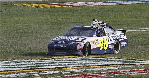 Jimmie Johnson drives through the infield after winning the NASCAR Sprint Cup Series auto race at Kansas Speedway in Kansas City, Kan., Sunday, Oct. 9, 2011.