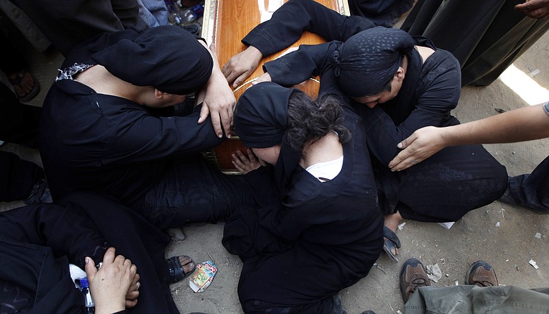 Egyptian relatives of one of the Copts who were killed during clashes with the Egyptian army late Sunday mourn over his coffin Monday outside the morgue of the Copts' hospital in Cairo, Egypt.