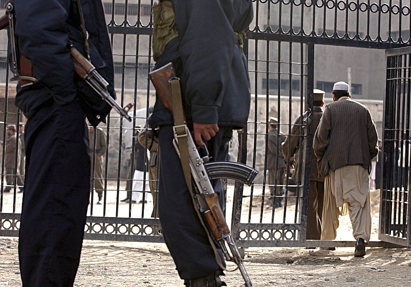 Afghan security police officers stand guard in December 2004 in front of the Pul-e Charkhi prison's gate in Kabul, Afghanistan. Prisoners in some Afghan-run detention facilities have been beaten and tortured, a United Nations report said Monday.