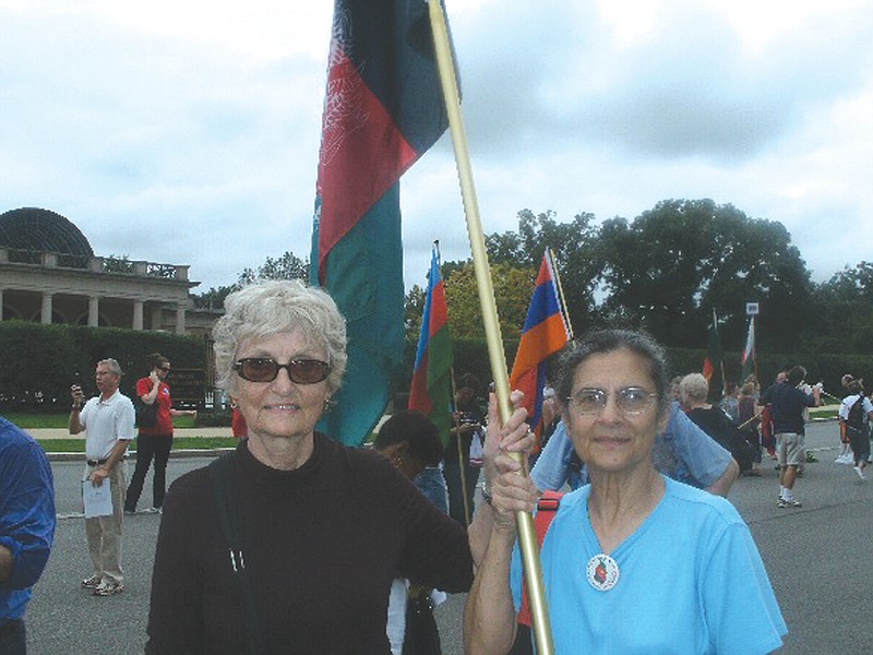 Edie Maxey, left, of Fulton, and her roommate while she was in Afghanistan, Louisa Furno, of Wheaton, Md., join thousands of past Peace Corps volunteers on Sept. 25 as they walk from Arlington Cemetery to the Lincoln Memorial carrying the flags of the countries in which they served. The Peace Corps celebrated its 50-year anniversary from Sept.22-25 in Washington, D.C.    