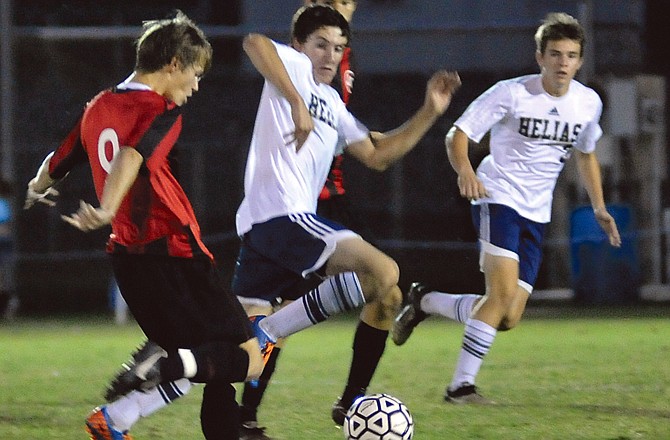 Jefferson City's Tyler Luebbert takes a shot as Helias players Kyle Dorge (center) and Chris Westermann (right) look on.