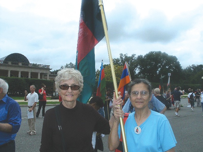 Edie Maxey, left, of Fulton, and her roommate while she was in Afghanistan, Louisa Furno of Wheaton, Md., join thousands of past Peace Corps volunteers on Sept. 25 as they walk from Arlington Cemetery to the Lincoln Memorial carrying the flags of the countries in which they served. The Peace Corps celebrated its 50-year anniversary from Sept.22-25 in Washington, D.C.    
