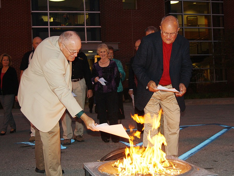 Fulton Mayor LeRoy Benton and former mayor Robert Craghead burn copies of the mortgage papers for City Hall Tuesday night. The city made the last payment on the building in September.