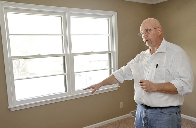 Ken Thoenen talks about green improvements that can be retrofitted to existing homes at a home on Denese Drive.