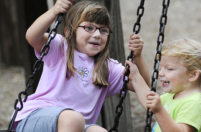 Allie Brizendine, 5, and Hollie Brizendine, 3, ride the tire swing at Memorial Park. The girls were visiting the park with their grandparents.