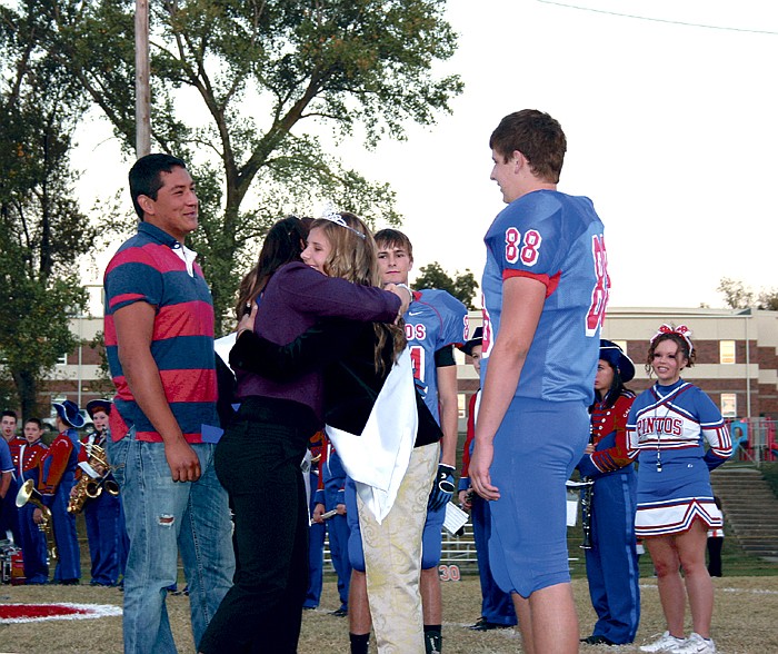 TyleRe Goans, the 2010 CHS Homecoming Queen, congratulates Elle Miller after crowning her the 2011 Homecoming Queen at the coronation Friday at Riley Field. At left is Goans' escort Pedro Corona and at right is Miller's escort Alec Ramsdell.