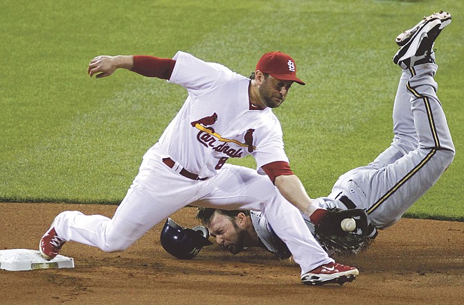 Milwaukee Brewers' Mark Kotsay is out at second as St. Louis Cardinals second baseman Nick Punto takes a throw on a fly out by Prince Fielder during the first inning of Game 3 of baseball's National League championship series Wednesday, Oct. 12, 2011, in St. Louis.  