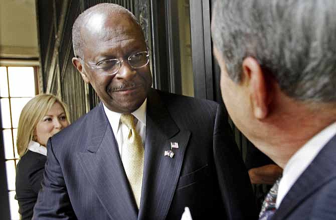 In this Oct. 12, 2011 file photo, Republican presidential candidate, businessman Herman Cain is greeted by lawmakers at the statehouse in Concord, N.H. One way surging GOP presidential candidate Cain has distinguished himself from his rivals is by calling for an alternative to Social Security. 