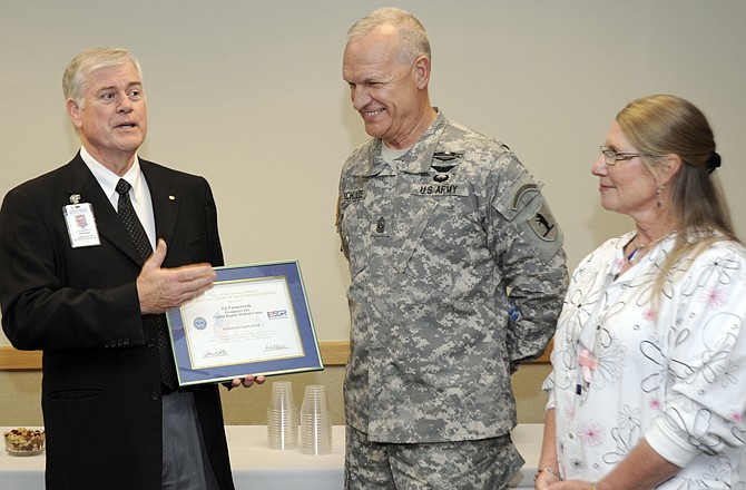 On behalf of Capital Region Medical Center, Ed Farnsworth, left, accepts a Patriot Award from the Missouri Committee for Employer Support of the Guard and Reserve. Registered nurse Janelle Fischer-Schulte, right, wife of Missouri National Guard Command Sgt. Maj. James Schulte, center, nominated her employer for the positive way the organization helped her during her husband's and stepson's deployments. 