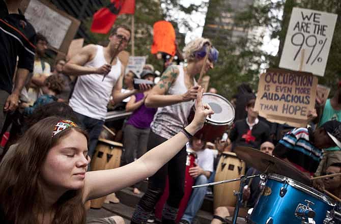In this Oct. 10, 2011 photo, a protester affiliated with the Occupy Wall Street demonstration listens to a drum circle in Zuccotti Park in New York. At the Occupy Wall Street protest camp in Manhattan, protesters agonized over what to do about drum players who had turned part of the site into an impromptu dance floor. The neighbors were complaining about the racket. The protesters had tried to put a time limit on the noise, but the drummers were refusing to obey. 