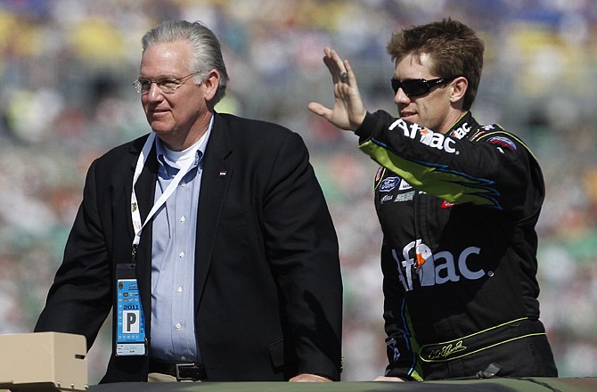 Missouri Gov. Jay Nixon, left, rides with driver Carl Edwards during introductions for the NASCAR Sprint Cup Series race at Kansas Speedway.