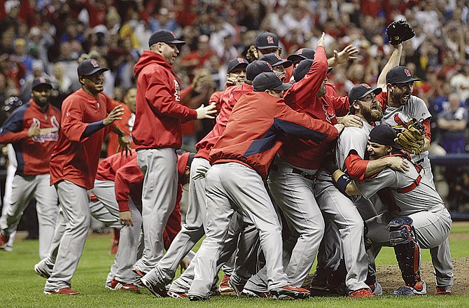 The Cardinals celebrate after winning the National League title Sunday night in Milwaukee.