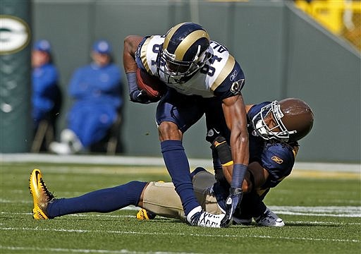 Green Bay Packers cornerback Tramon Williams, bottom right, tackles St. Louis Rams wide receiver Danario Alexander (84) during the first half of an NFL football game Sunday, Oct. 16, 2011, in Green Bay, Wis.