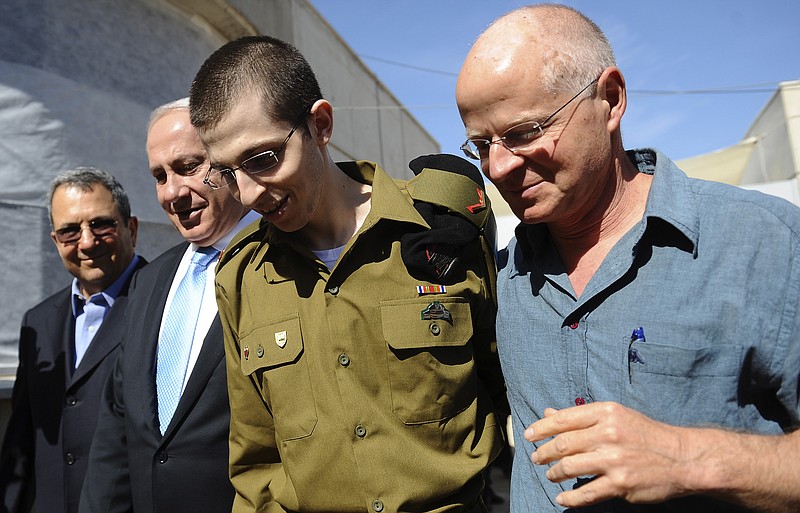 Released Israeli soldier Gilad Schalit, is escorted Tuesday by his father, Noam Schalit, right, Prime Minister Benjamin Netanyahu and Defense Minster Ehud Barak as he arrives at Tel Nof Air base in Israel. Schalit was exchanged for 1,000 Palestinian prisoners.