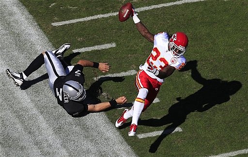 Kansas City Chiefs free safety Kendrick Lewis (23) runs past a diving Oakland Raiders quarterback Kyle Boller (7) on a 59-yard interception for a touchdown in the first quarter of an NFL football game in Oakland, Calif., Sunday, Oct. 23, 2011. 