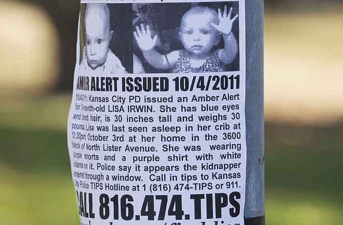 In this Oct. 11, 2011, file photo posters for missing baby Lisa Irwin are taped to a light pole near the Irwin home in Kansas City, Mo. The pictures on the "KIDNAPPED" flier have put an emotional face on what could have been simply just another missing person's case. Lisa's parents reported her missing Oct. 4.