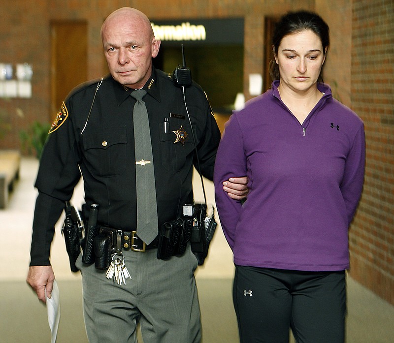 Stacy Schuler, right, is escorted by Warren County Sheriff's Deputy Hank Arnett after she turned herself in at the Warren County Courts Building in Lebanon, Ohio. She is accused of having sex with several male students at Mason High School in southwest Ohio.