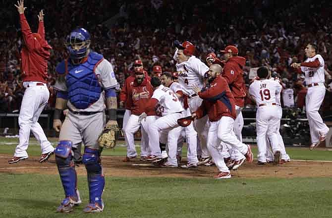 Texas Rangers catcher Mike Napoli walks away as the St. Louis Cardinals celebrate after David Freese hit a walk-off home run during the 11th inning of Game 6 of baseball's World Series Thursday, Oct. 27, 2011, in St. Louis. 