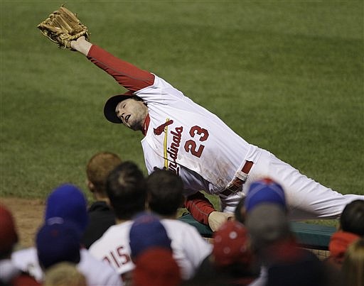 St. Louis Cardinals' David Freese catches a foul ball hit by Texas Rangers' Josh Hamilton during the fifth inning of Game 7 of baseball's World Series Friday, Oct. 28, 2011, in St. Louis.