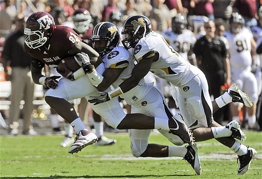 Texas A&M tight end Nehemiah Hicks (81) gains yardage as Missouri defenders Braylon Webb, center, and Kenji Jackson try to slow him down during the first half of an NCAA college football game Saturday, Oct. 29, 2011, in College Station, Texas.