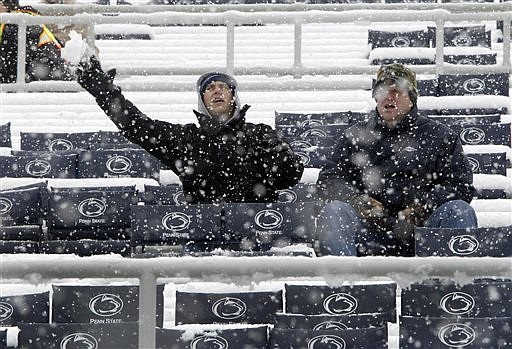 Dennis Koscho, left, and Pat Hays sit in their seats as snow falls before an NCAA college football game between Penn State and Illinois, in State College, Pa., on Saturday, Oct. 29, 2011.