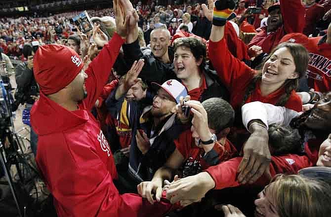 St. Louis Cardinals' Albert Pujols celebrates with fans after Game 7 of baseball's World Series against the Texas Rangers Friday, Oct. 28, 2011, in St. Louis. The Cardinals won 6-2 to win the series.