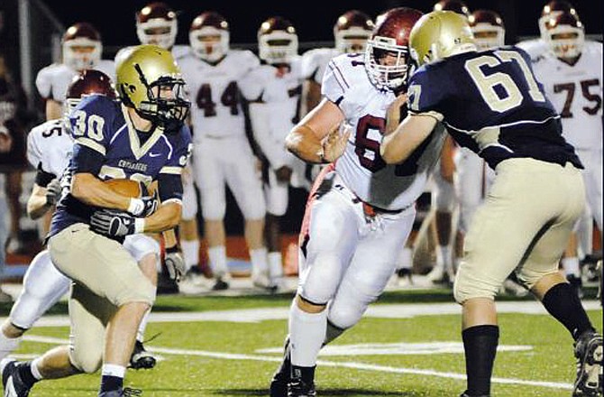 With teammate Will Fife (67) throwing a block, Brendan Roberts runs the ball for Helias during a game earlier this season against Warrensburg at Adkins Stadium. Roberts and the Crusader offense have come alive in the past three games as Helias prepares to host Carthage tonight in a Class 4 regional game. 