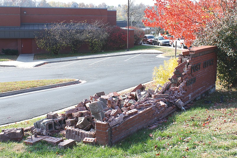 The sign in front of the Fulton Post Office sits in a demolished state Friday after a car crashed into it Thursday evening.