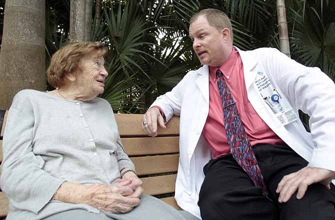 In this Oct. 7, 2011 photo, Dr. Brian Kiedrowski, right, talks to his patient Victoria Cohen, 100, in Miami. The baby boomers entrance into old age is casting light on the drastic shortage of medical professionals trained to treat the elderly.