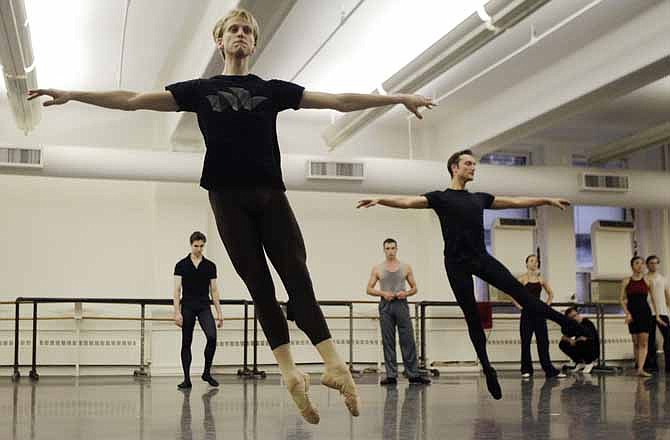 In this Wednesday, Sept. 28, 2011 photo, David Hallberg, 29, front, regarded as one of the most talented male ballet dancers in the world, practices during a class with American Ballet Theatre dancers in New York. In a reversal of tradition, the young American ballet star will be debuting in Moscow this weekend as a premier dancer with the famed Bolshoi Ballet.