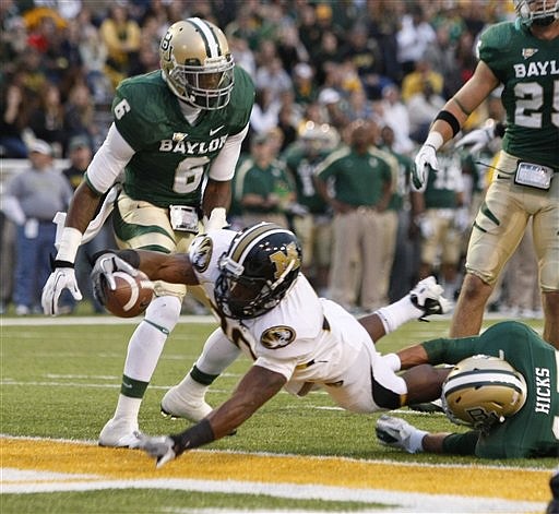 Missouri running back Henry Josey (20) scores past Baylor's Ahmad Dixon, left, and Mike Hicks in the first half of an NCAA college football game, Saturday, Nov. 5, 2011, in Waco, Texas. (AP Photo/Waco Tribune Herald, Jose Yau)