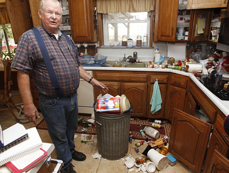 Joe Reneau displays the damage Sunday his home after two earthquakes in less than 24 hours in Sparks, Okla. Reneau said the trash can at center had been filled with items damaged in an early morning quake on Saturday. The items on the floor and countertops spilled out of the cabinets during a quake on Saturday night. No injuries were reported, and aside from a buckled highway and a damaged university building, there was no major damage.