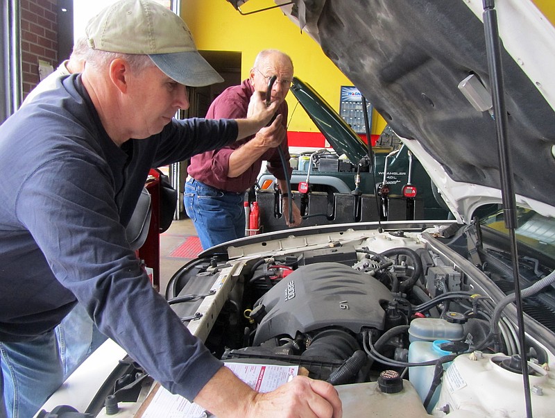 Mike Logston, left, and Ray Kinnamon take a look under the hood of a car on Sunday at Concord Baptist Church's event to give oil changes and checks on cars owned by single women in the community. Kwik Car Lube & Tune, 3636 W. Truman Blvd., donated use of the business and five employees who volunteered along with the church volunteers.