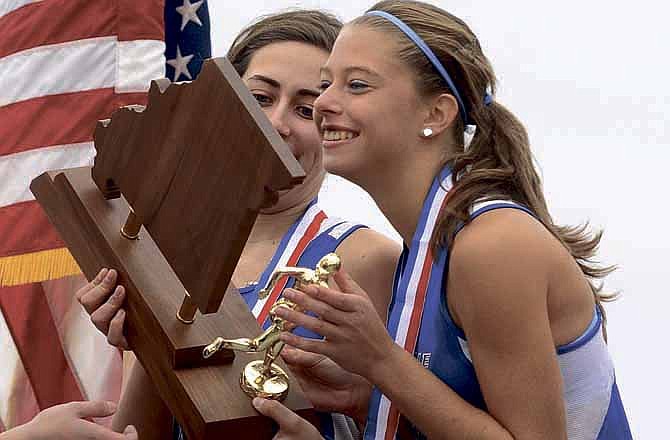 Russellville senior Izabella Michitsch, left, holds the championship trophy as teammate Miranda Hill leans in to give it a kiss following Russellville's repeat as Girls Class 1 champions at the Cross Country Championships at Oak Hills Golf Center in Jefferson City on Saturday. 