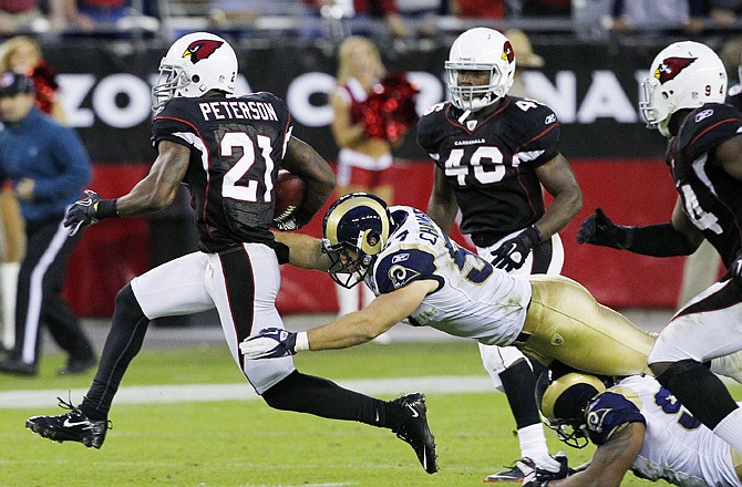 Patrick Peterson of the Cardinals breaks free from the grasp of Chris Chamberlain of the Rams on a 99-yard, game-winning punt return in overtime during Sunday's game in Glendale, Ariz.